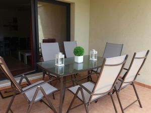 a glass table with chairs and a potted plant on it at Apartamento unifamiliar Golf Vera urb privada y tranquila in Vera