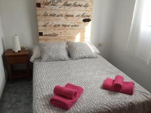 a bedroom with a bed with two red roses on it at Tranquilo y Acogedor Apartamento in Órzola