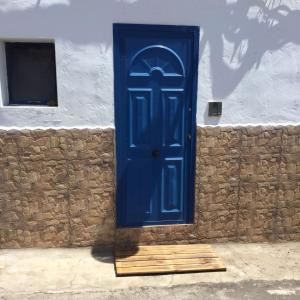 una puerta azul en el lateral de un edificio en Tranquilo y Acogedor Apartamento, en Orzola