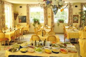 a dining room with tables filled with food at Garden Hotel Bellariva in Molveno +27 photos