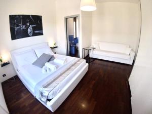 シラクーサにあるMythos Affittacamereのベッドルーム(大きな白いベッド1台、ソファ付)