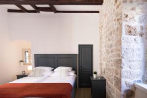 een slaapkamer met 2 bedden en een bakstenen muur bij Mediterraneo Luxury Rooms in Šibenik