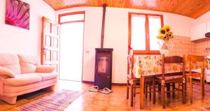 a living room with a couch and a table and a stove at Bilocale indipendente tellino in Teglio