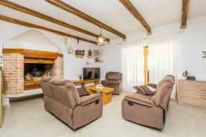 a living room with two chairs and a fireplace at Holiday house Hojevica - Kras, Krk in Kras
