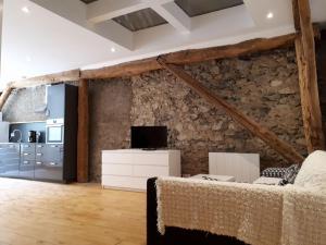 a living room with a stone wall and a couch at Domaine de la Safranière - Holiday Home in Saint-Léger