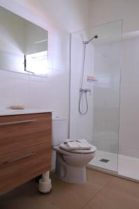 a white bathroom with a toilet and a shower at Es Mitjorn in San Antonio