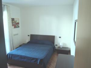 a bedroom with a bed with a blue bedspread at Casa Vacanze Marone in Marone