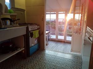 a kitchen with a stove and an open door at Botanico Hostel in Bogotá