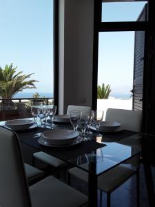 a dining table with glasses and a view of the ocean at Central Seaview Apartment Puerto del Carmen in Puerto del Carmen
