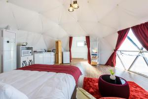 - une chambre avec un grand lit dans une tente dans l'établissement Jeju Starlight Glamping, à Jeju