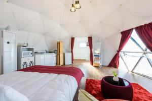 een slaapkamer met een groot bed in een tent bij Jeju Starlight Glamping in Jeju-stad