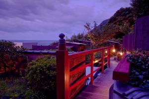 a wooden deck with a view of the ocean at night at Hiina in Higashiizu