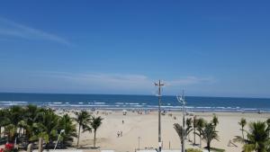 ein Strand mit vielen Menschen und dem Ozean in der Unterkunft Vista para o Mar Praia Grande in Praia Grande