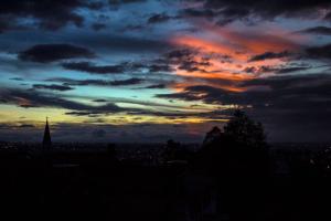 a sunset over a city with a tower in the distance at Botanico Hostel in Bogotá