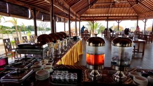 a restaurant with a long table with food on it at Padadita Beach Hotel in Waingapu