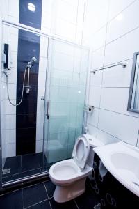 een badkamer met een douche, een toilet en een wastafel bij Labuan Fortune Hotel in Labuan