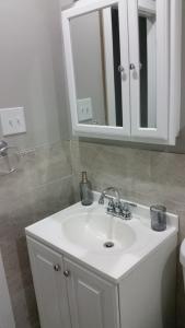 a bathroom with a white sink and a mirror at Cozy Retreat on Atlantic Ave in Brooklyn