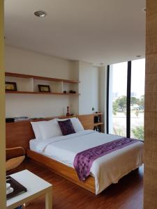 a bedroom with a large bed and a large window at Tainan Anping - Shuiau 180 in Anping