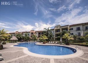 a large swimming pool in front of a building at Ocean View Condo in Los Sueños in Herradura