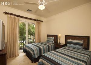 a bedroom with two beds and a window at Ocean View Condo in Los Sueños in Herradura