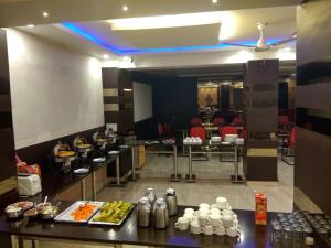 a restaurant with a buffet line with food on display at FabHotel Vardhmaan Inn in New Delhi
