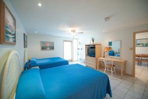 a bedroom with a blue bed and a living room at South Padre Island Beach Rentals in South Padre Island