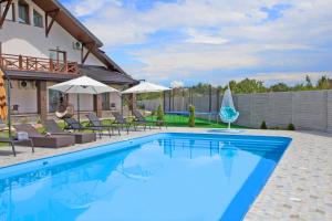 a swimming pool in a backyard with a house at ART Boutique Chalet in Yanoshi