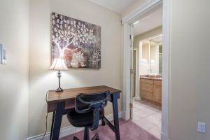 a home office with a desk and a lamp at Quail Ridge in Kelowna