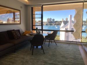 a living room with a couch and chairs and a large window at The KC Elizabeth Bay in Sydney