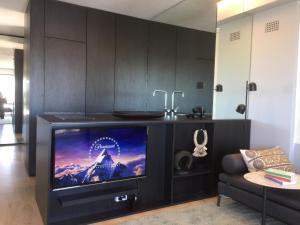 a living room with a tv on a stand at The KC Elizabeth Bay in Sydney