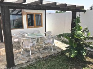 a patio with a table and chairs in front of a house at Sol de Bolonia 5 in Bolonia