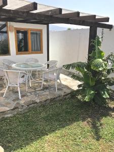 un patio con mesa y sillas frente a una casa en Sol de Bolonia 5 en Bolonia