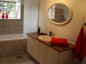 a bathroom with a sink and a tub and a mirror at Klitgaards Holiday Apartment in Mejeriby +23 photos