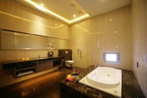 baño con bañera grande y lavamanos en Dubai Villa Motel, en Daya