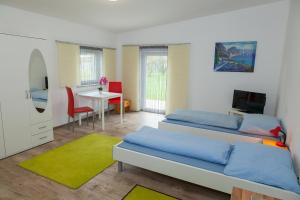 a bedroom with two beds and a table with a television at Gästepension Sport 71 in Strasshof an der Nordbahn