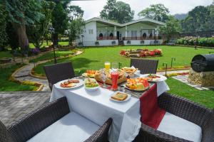 a table with plates of food and drinks on it at La Grande Villa in Nuwara Eliya