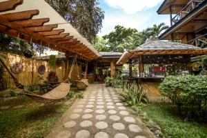 a patio with a hammock outside of a house at Puerto Pension Inn in Puerto Princesa City