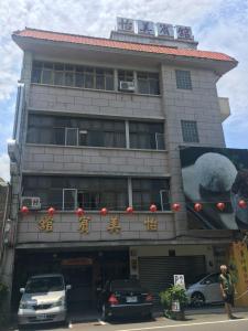 ein Gebäude mit davor geparkt in der Unterkunft Yi Mei Hotel in Jinshan