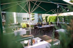 
a patio area with tables, chairs, and umbrellas at Hotel Domizil in Ingolstadt
