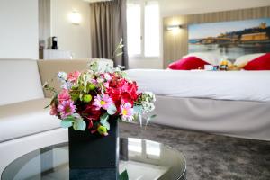un jarrón de flores sobre una mesa en una habitación de hotel en Hôtel Saphir Lyon en Lyon