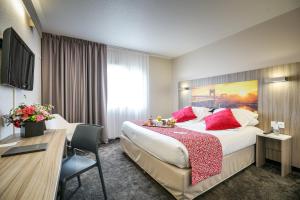 una habitación de hotel con una cama grande con almohadas rojas en Hôtel Saphir Lyon, en Lyon
