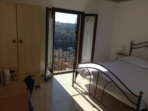 ein Schlafzimmer mit einem Bett und einem großen Fenster in der Unterkunft B&B La Terrazza Dell'Itria in Modica