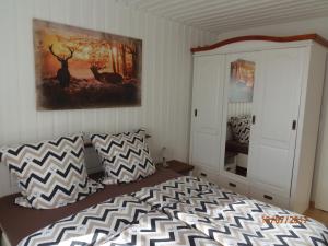 フリードリヒスハーフェンにあるFerienwohnung Desiréeのベッドルーム1室(ベッド1台付)が備わります。壁には絵画が飾られています。