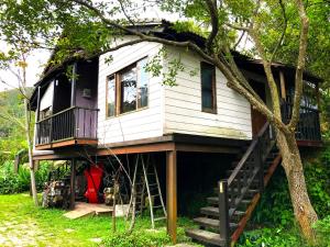 a tree house with a staircase leading up to it at 山板樵愛面子民宿 in Sanyi