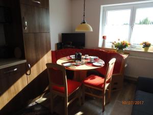 een kleine tafel en stoelen in een kleine kamer met een bank bij Ferienwohnung Desirée in Friedrichshafen
