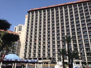 un gran edificio con palmeras delante en Hotel Marina Resort, en Benidorm