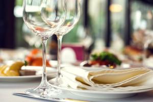 a table with two wine glasses and a plate of pasta at Hotel Aateli Hillside in Vuokatti