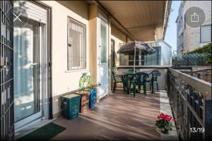 a balcony with a table and chairs and an umbrella at Appartamento Serapo in Gaeta