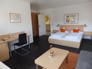 a hotel room with a bed and a desk at H41 Inn Hotel Garni Freiburg in Freiburg im Breisgau