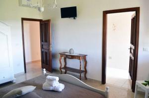 Zimmer mit einem Bett, einem Tisch und einem TV in der Unterkunft B&B Profumo di Alloro in Tricase